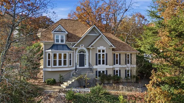 a front view of a house with yard and green space