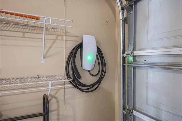 a view of a backyard with table and chairs potted plants and large tree