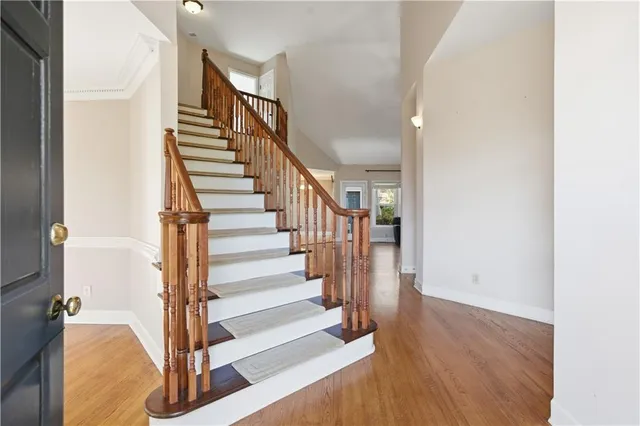a view of staircase with wooden floor and white walls