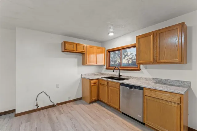 a view of a kitchen with wooden floor and a sink