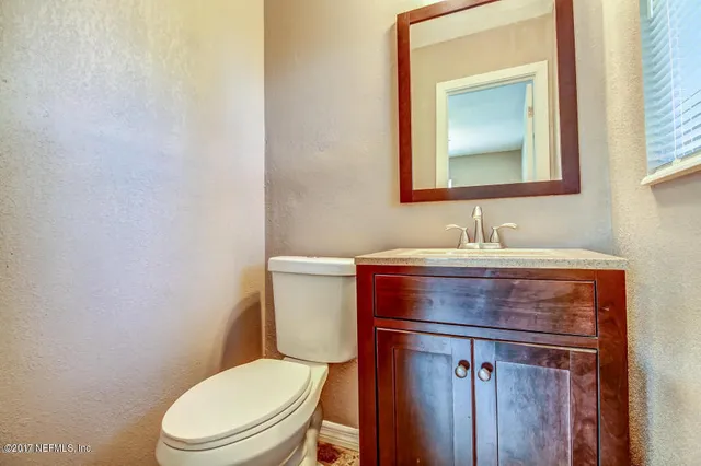 a bathroom with a toilet a sink and mirror