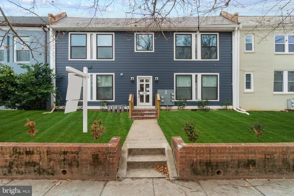 a front view of a house with a yard and potted plants