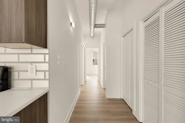 a view of a hallway with wooden floor and entryway