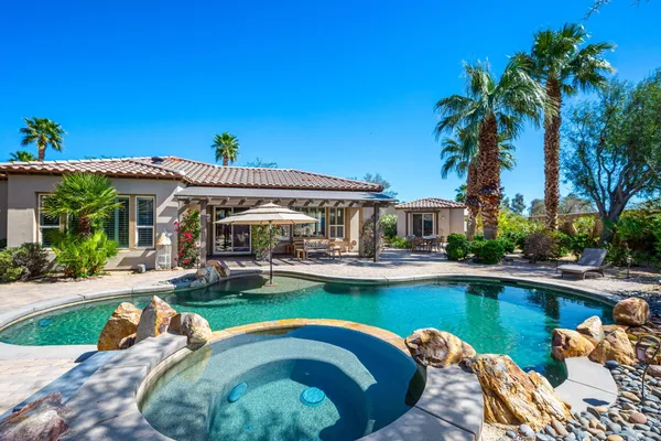 a front view of a house with swimming pool having outdoor seating