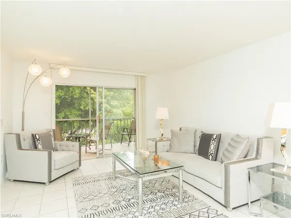 a living room with furniture and a floor to ceiling window