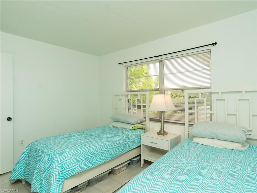 499 Forest Lakes Boulevard, Unit 2309 Naples, FL 34105 - Photo 16 of 29 a bedroom with a bed and a night stand