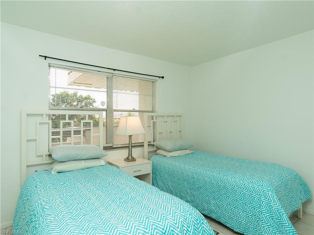 499 Forest Lakes Boulevard, Unit 2309 Naples, FL 34105 - Photo 17 of 29 a bedroom with a bed and a large window