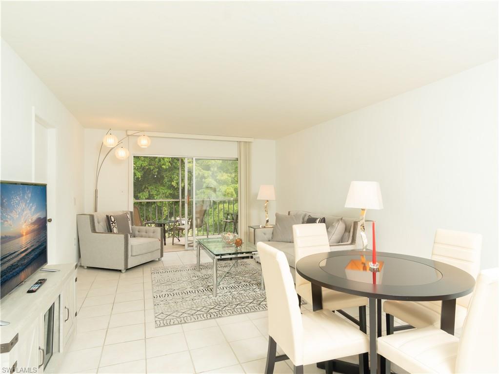 499 Forest Lakes Boulevard, Unit 2309 Naples, FL 34105 - Photo 5 of 29 a living room with furniture and a flat screen tv