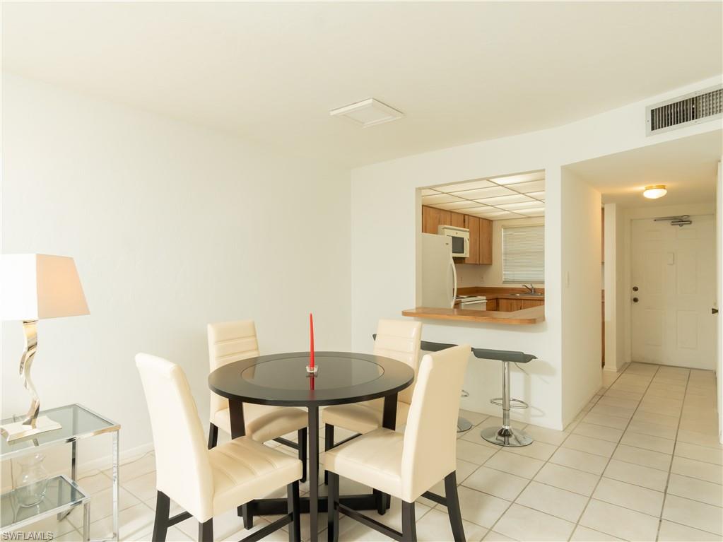 499 Forest Lakes Boulevard, Unit 2309 Naples, FL 34105 - Photo 8 of 29 a view of a dining room with furniture and a potted plant