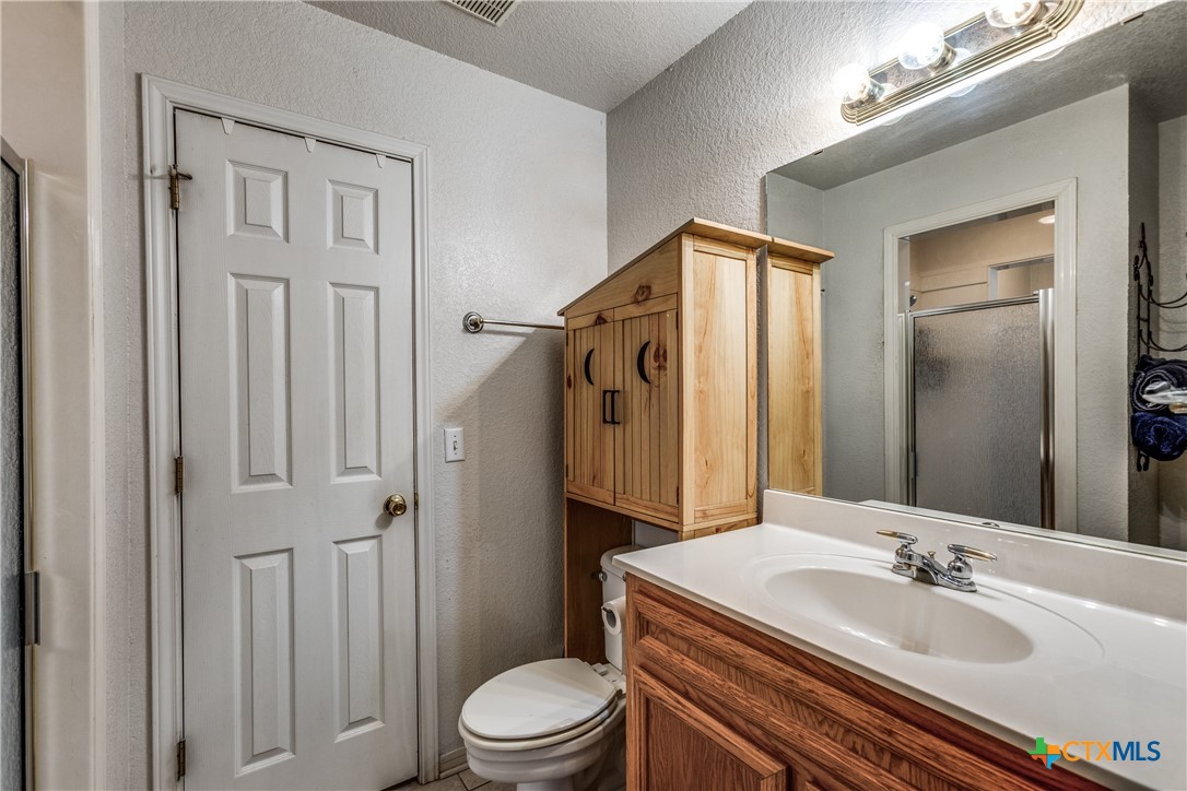1408 County Road 3300 Kempner, TX 76539 - Photo 17 of 25 a bathroom with a sink a toilet a mirror and shower