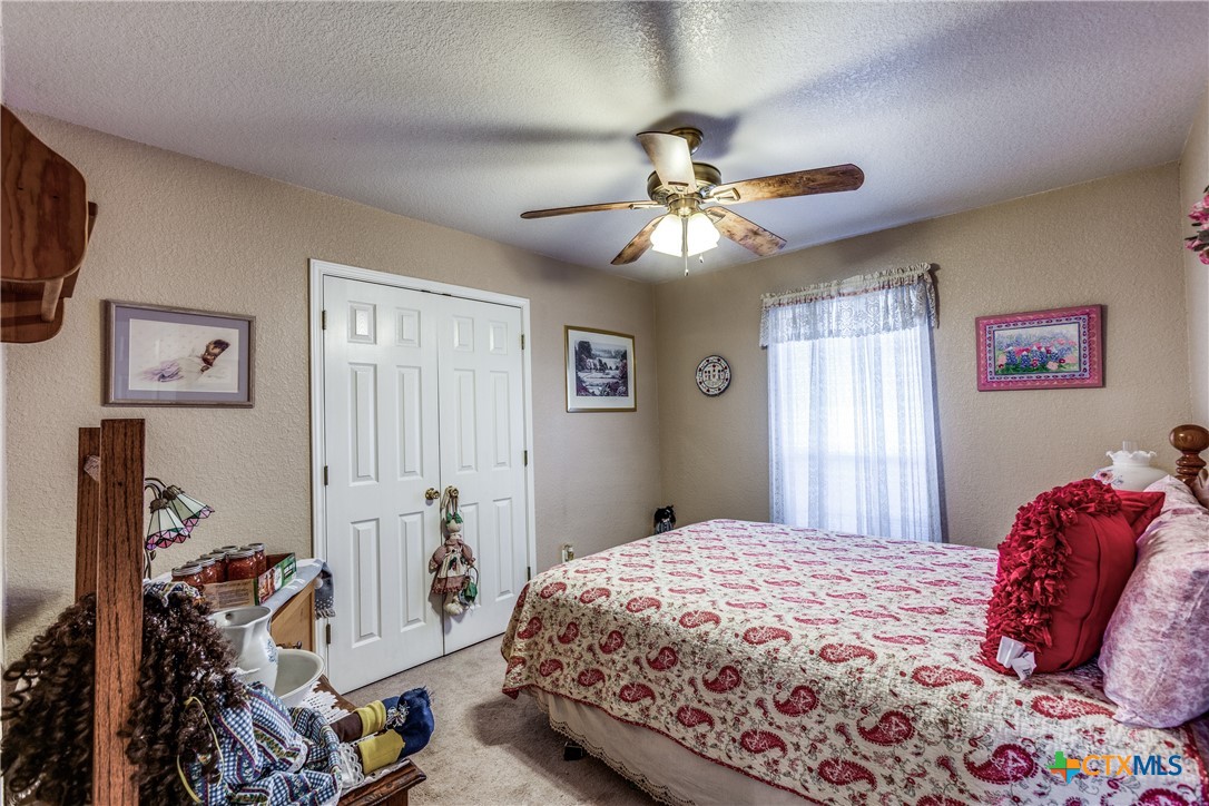 1408 County Road 3300 Kempner, TX 76539 - Photo 19 of 25 a bedroom with a bed and a chandelier