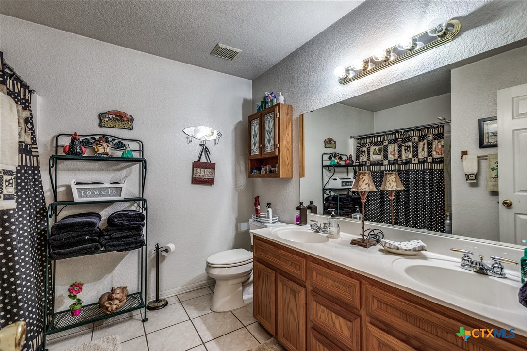 1408 County Road 3300 Kempner, TX 76539 - Photo 20 of 25 a bathroom with a double vanity sink and a mirror