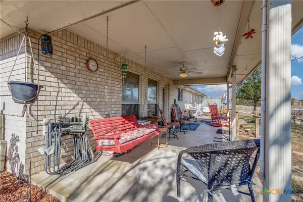 a view of a patio with a table and chairs under an umbrella