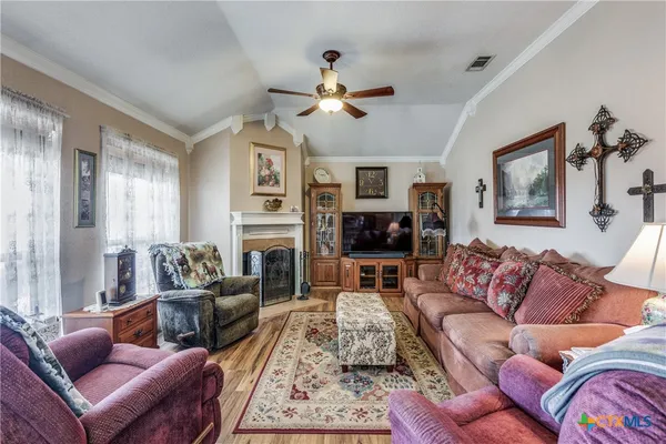 a living room with furniture a fireplace and a chandelier