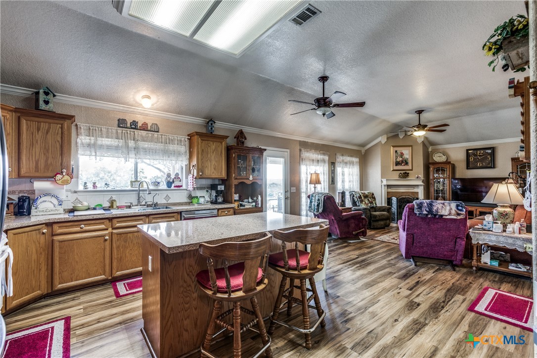 1408 County Road 3300 Kempner, TX 76539 - Photo 7 of 25 a open kitchen with stainless steel appliances granite countertop a stove dining table chairs cabinets and a sink