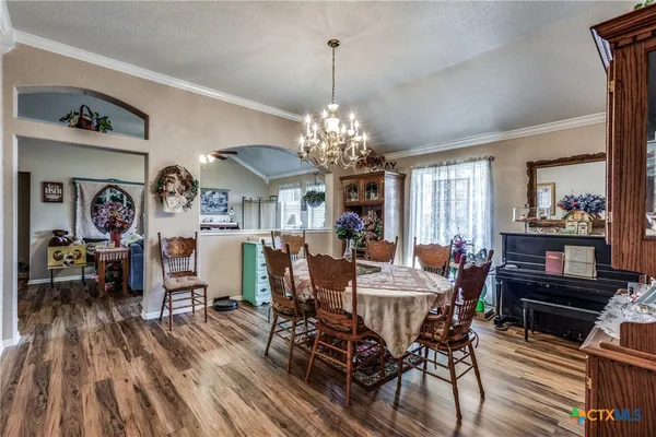 a view of a dining room with furniture and chandelier