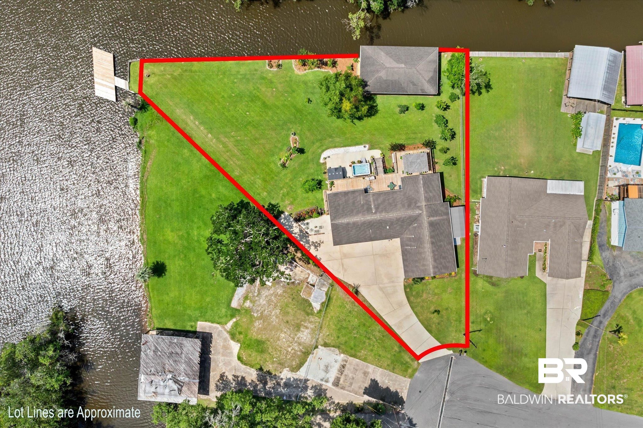 3801 Point Road Mobile, AL 36619 - Photo 41 of 55 Waterfront property featuring a private dock, expansive green lawn, and a paved driveway leading to the residence