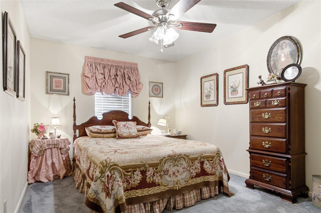 14202 Valleyview Ridge Tyler, TX 75709 - Photo 16 of 29 a bedroom with a bed a chandelier and a dresser
