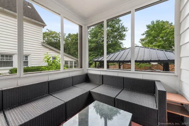 a backyard of a house with table and chairs under an umbrella