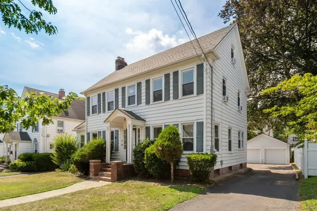 a couple of table and chairs in front of house