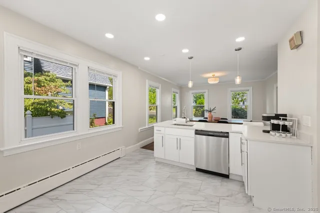 a kitchen with white cabinets and sink