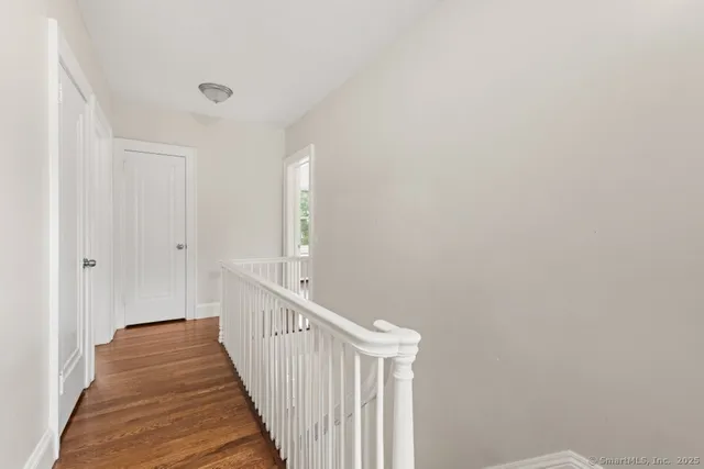 a view of a hallway with wooden floor and staircase