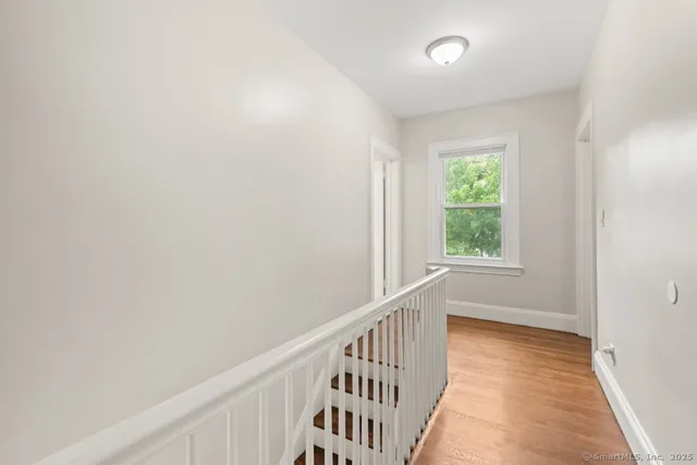 a view of a hallway with wooden floor and windows