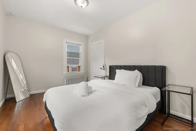 a bedroom with a bed and wooden floor