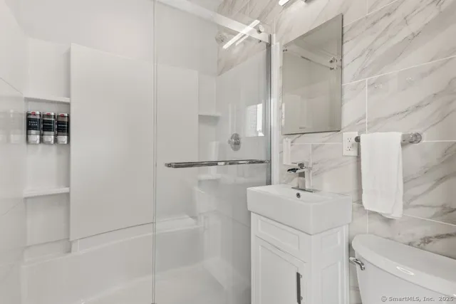 a bathroom with a sink a toilet and shower