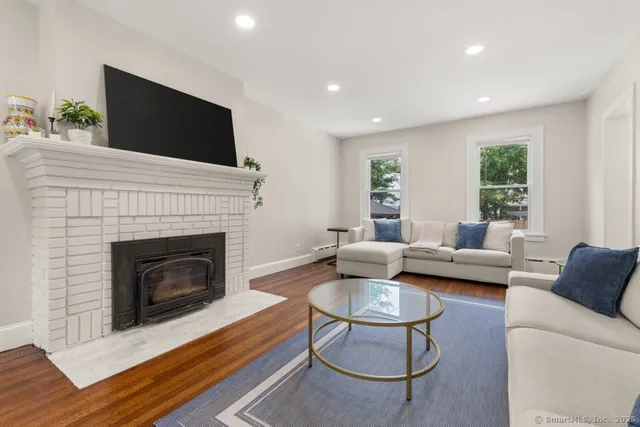 a living room with furniture a flat screen tv and a fireplace