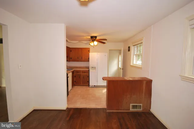 a view of a livingroom with wooden floor and a ceiling fan