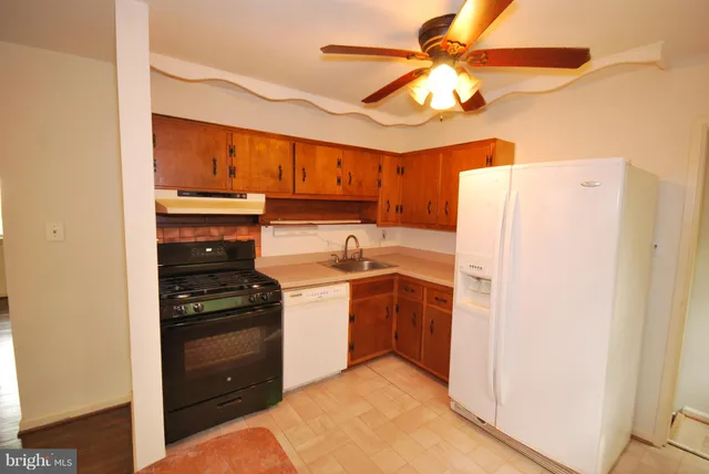 a kitchen with a sink a refrigerator and cabinets