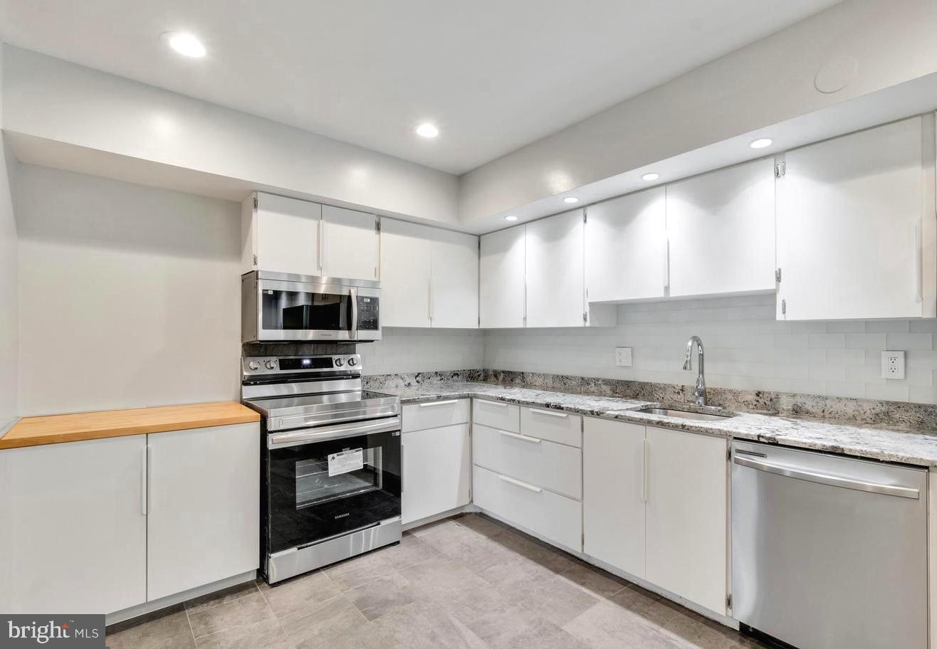 33 Stonehenge Circle, Unit 11 Baltimore, MD 21208 - Photo 8 of 22 a kitchen with stainless steel appliances granite countertop a sink and dishwasher a stove top oven with white countertops