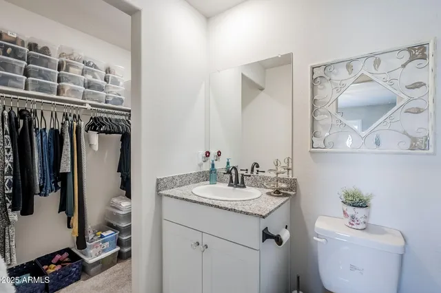 a bathroom with a granite countertop sink a toilet and shower