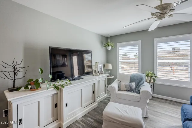 a living room with furniture a flat screen tv and a window