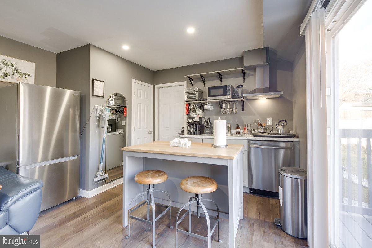 6604 Oak Street Cheverly, MD 20785 - Photo 3 of 16 a kitchen with stainless steel appliances a refrigerator a sink dishwasher and a stove with wooden floor