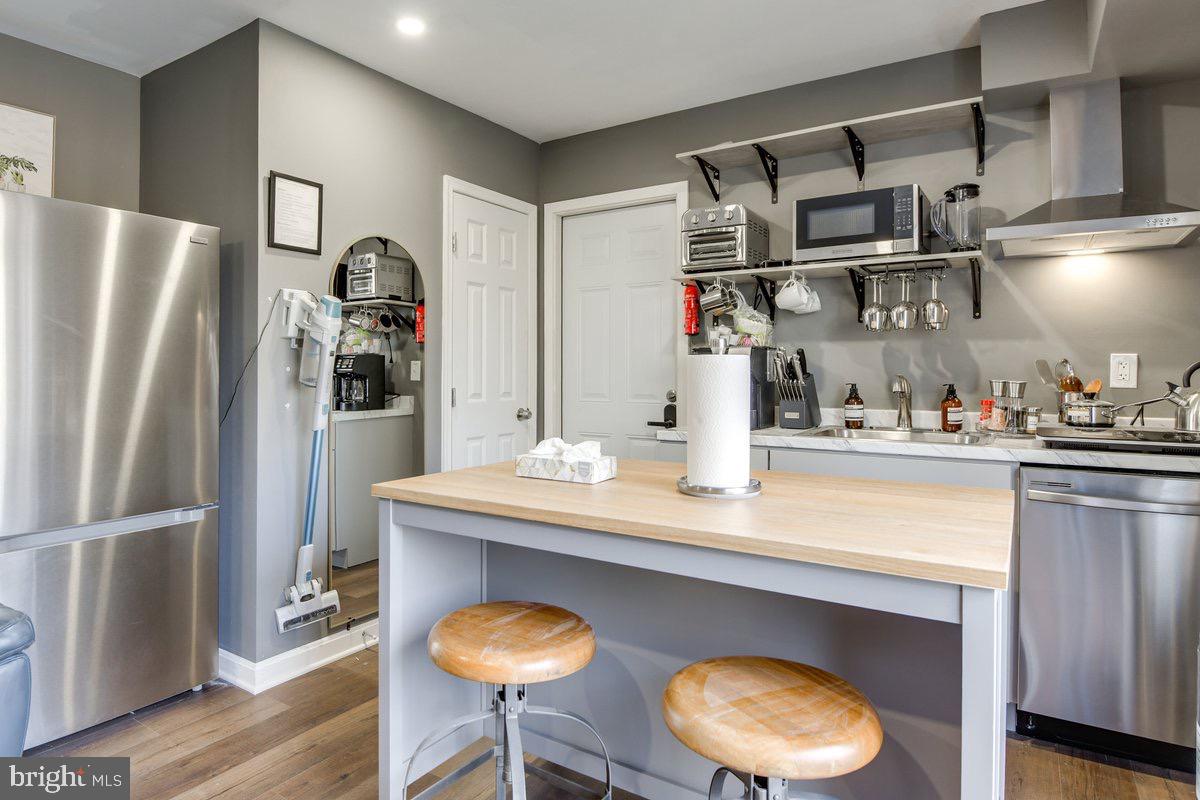 6604 Oak Street Cheverly, MD 20785 - Photo 6 of 16 a kitchen with stainless steel appliances granite countertop a refrigerator and a wooden floor