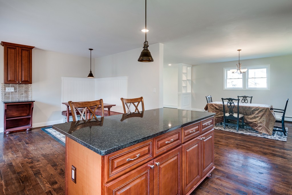 10 Felch Road Natick, MA 01760 - Photo 15 of 27 a kitchen with granite countertop a table chairs sink and wooden floor