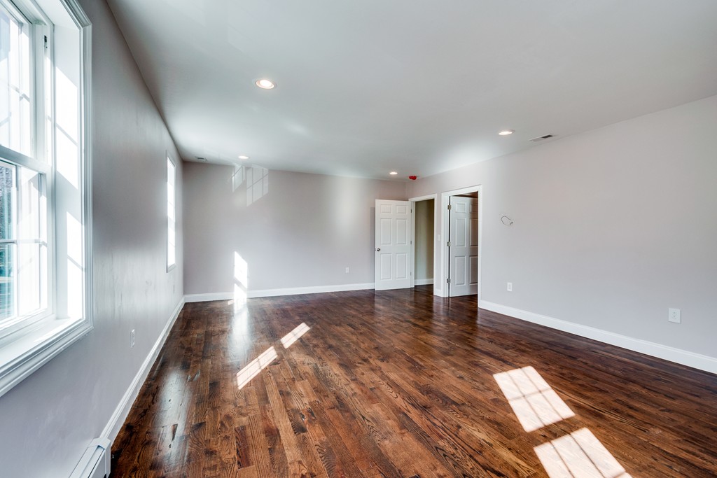 10 Felch Road Natick, MA 01760 - Photo 19 of 27 a view of an empty room with wooden floor and a window