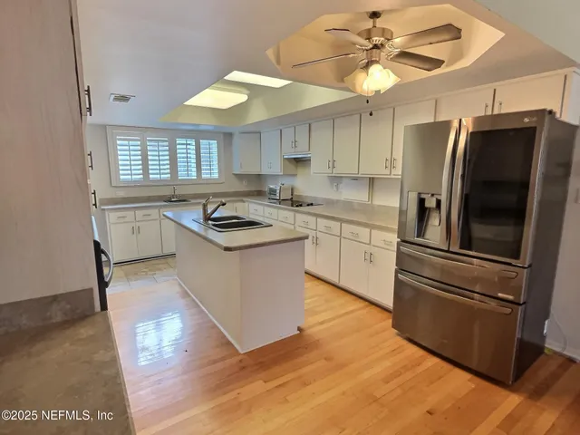 a kitchen with granite countertop stainless steel appliances a stove a sink a refrigerator cabinets and dining table