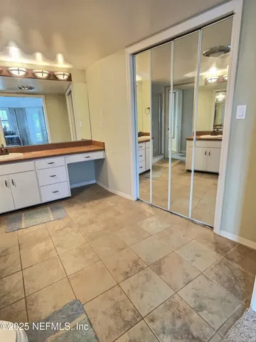 a spacious bathroom with a granite countertop sink toilet a mirror and a bathtub