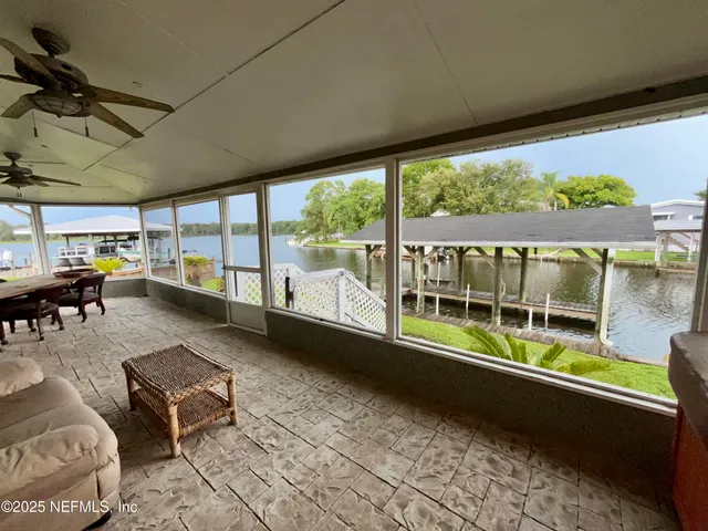 a view of a room with a ceiling fan and windows