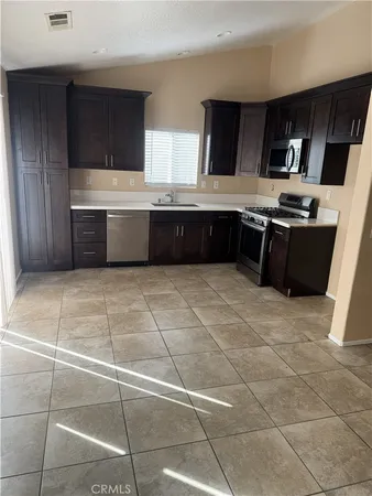 a kitchen with stainless steel appliances a sink a stove a microwave and a refrigerator