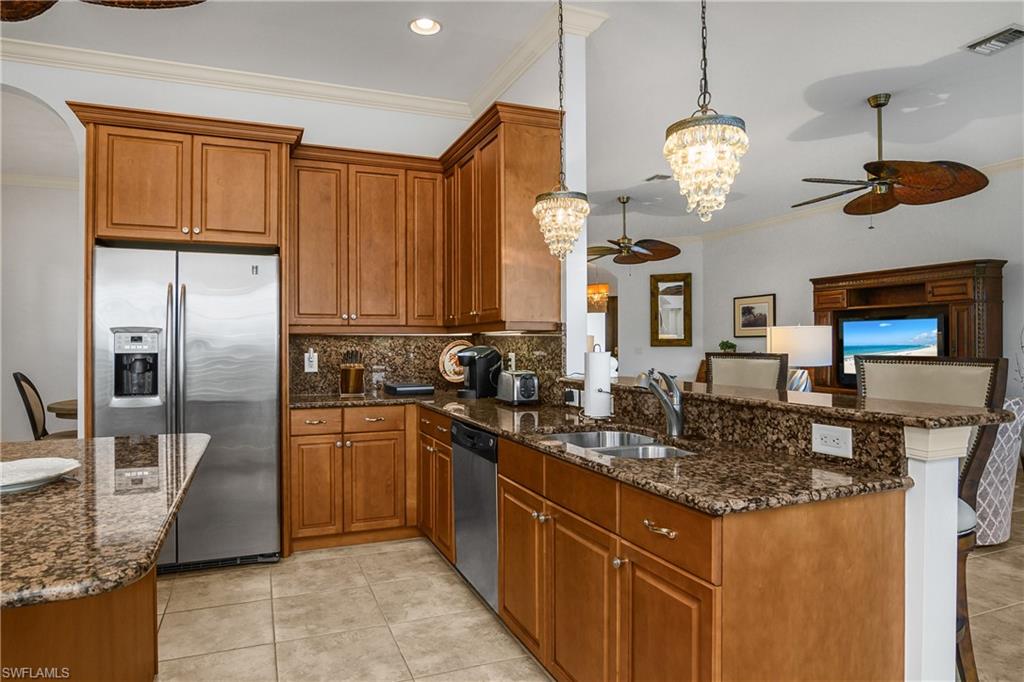 9109 Prima Way, Unit 102 Naples, FL 34113 - Photo 11 of 50 a kitchen with stainless steel appliances granite countertop a sink a stove and a refrigerator