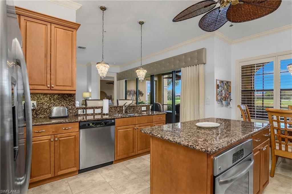9109 Prima Way, Unit 102 Naples, FL 34113 - Photo 13 of 50 a kitchen with stainless steel appliances granite countertop stove top oven a sink and dishwasher