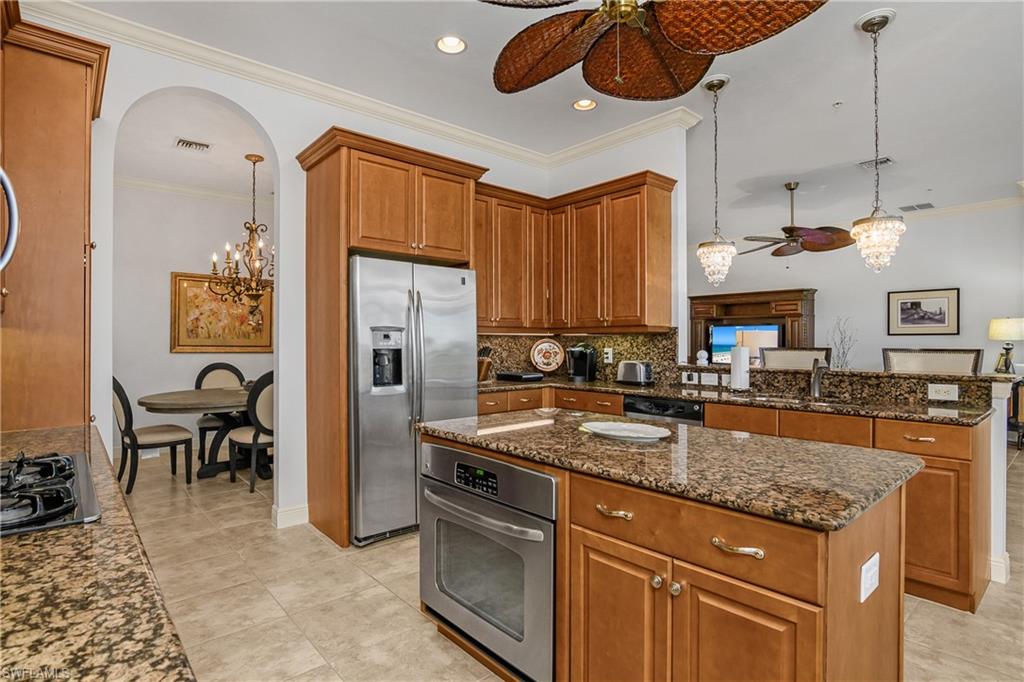 9109 Prima Way, Unit 102 Naples, FL 34113 - Photo 14 of 50 a kitchen with stainless steel appliances granite countertop a sink and a refrigerator