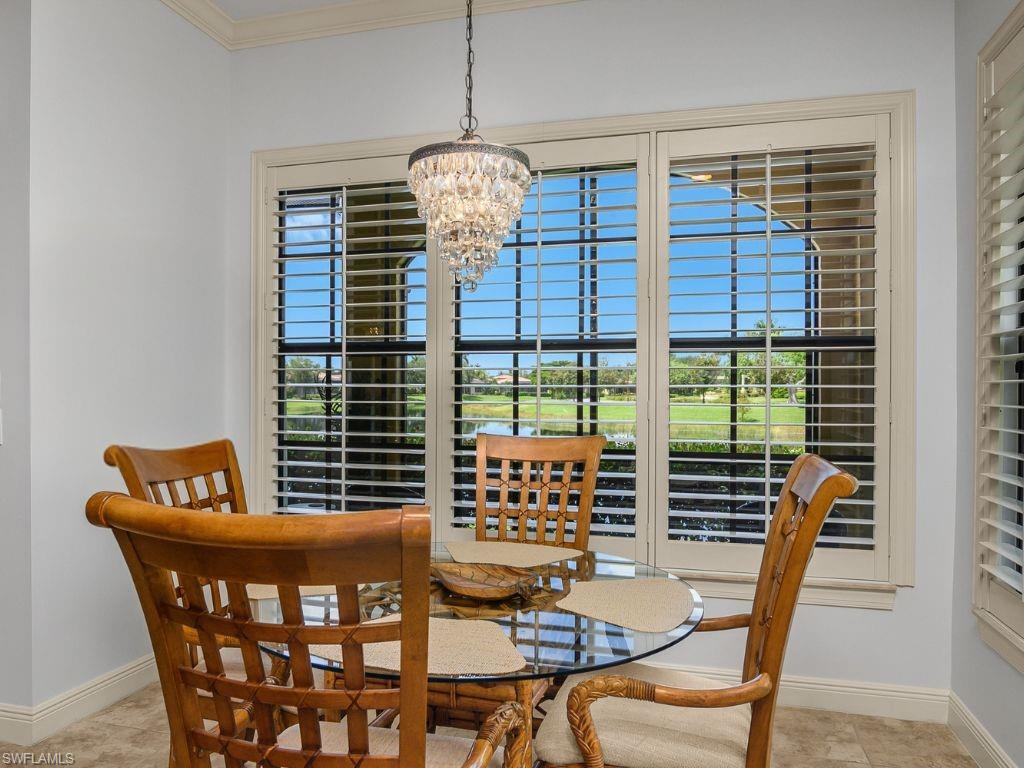 9109 Prima Way, Unit 102 Naples, FL 34113 - Photo 16 of 50 a view of a dining room with furniture and chandelier