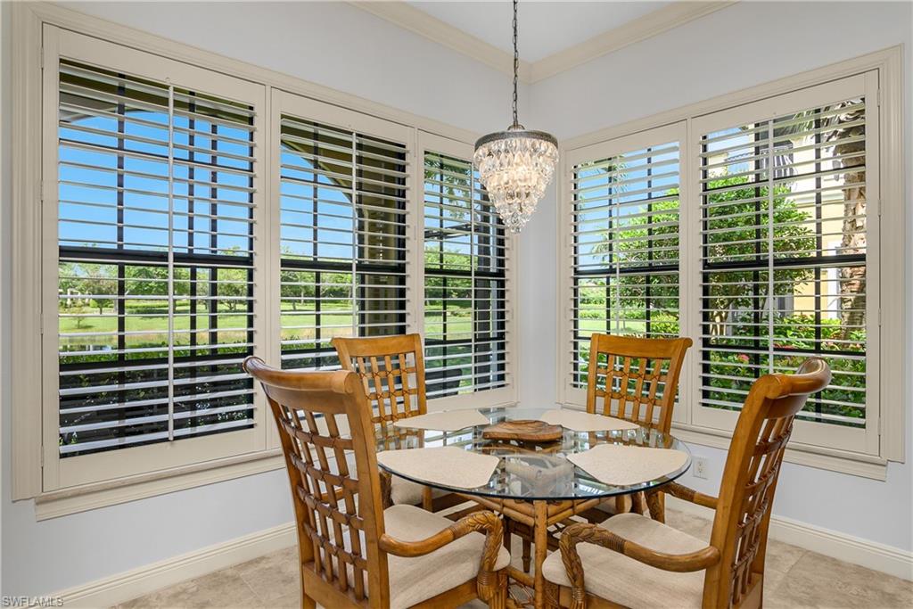 9109 Prima Way, Unit 102 Naples, FL 34113 - Photo 17 of 50 a view of a dining room with furniture wooden floor and chandelier