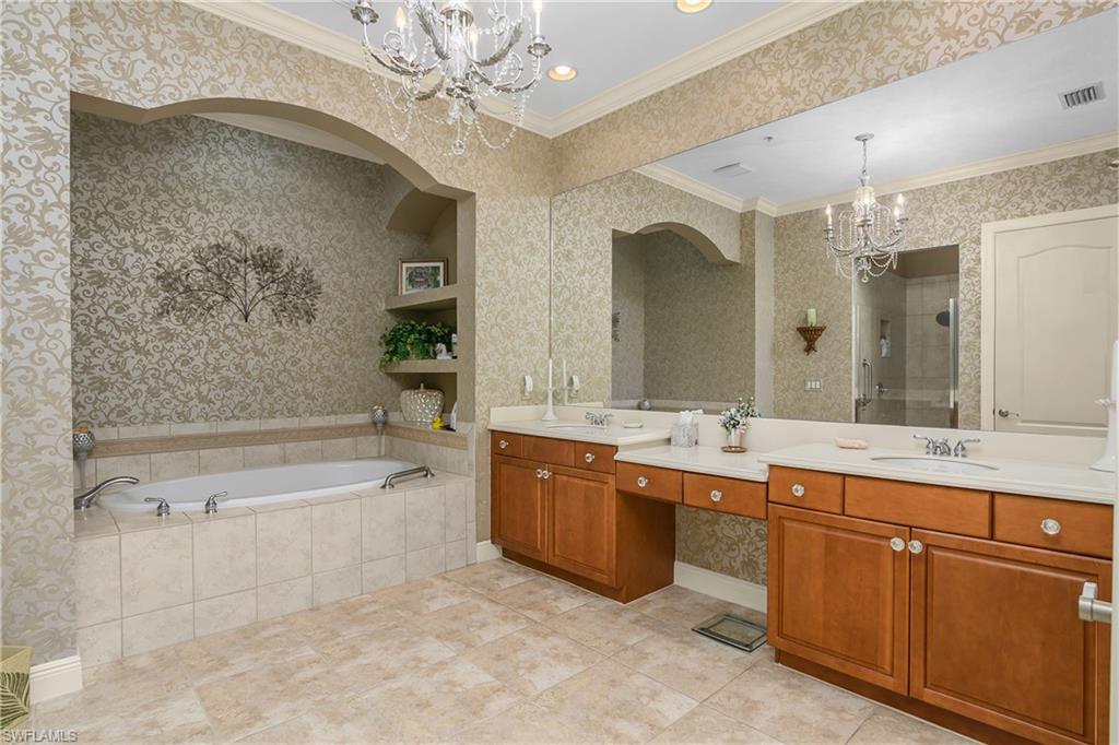 9109 Prima Way, Unit 102 Naples, FL 34113 - Photo 21 of 50 a spacious bathroom with a bathtub sink and mirror