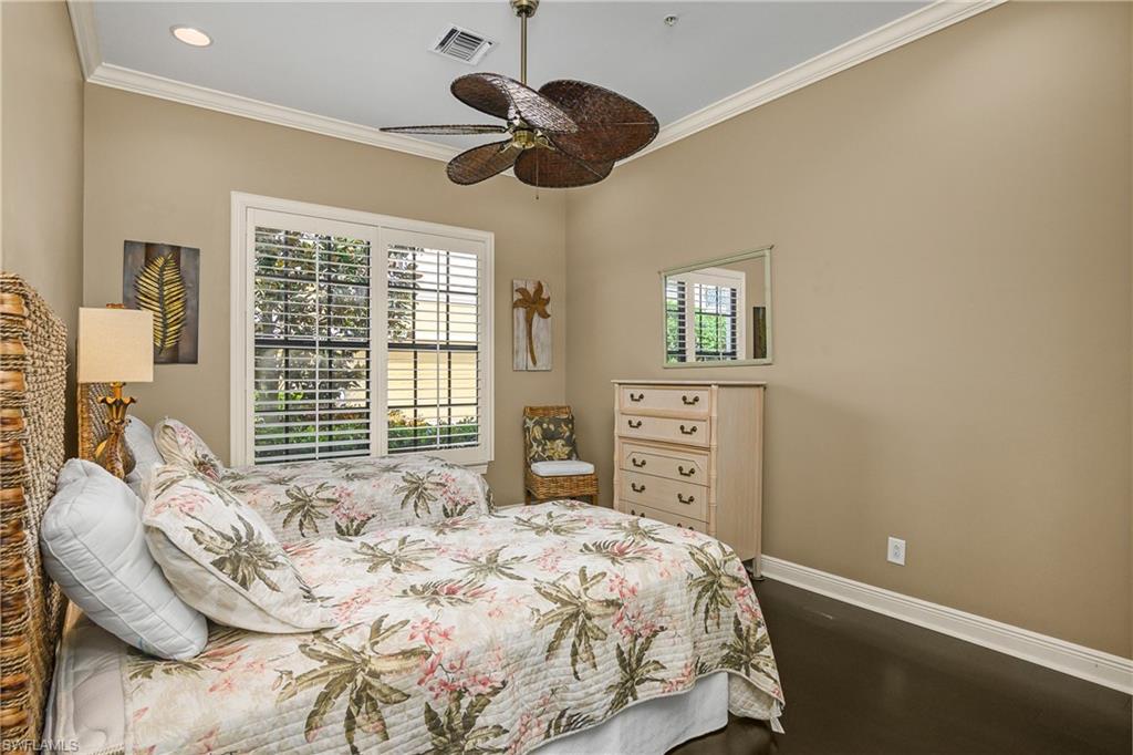 9109 Prima Way, Unit 102 Naples, FL 34113 - Photo 25 of 50 a bedroom with a bed a dresser and a large window